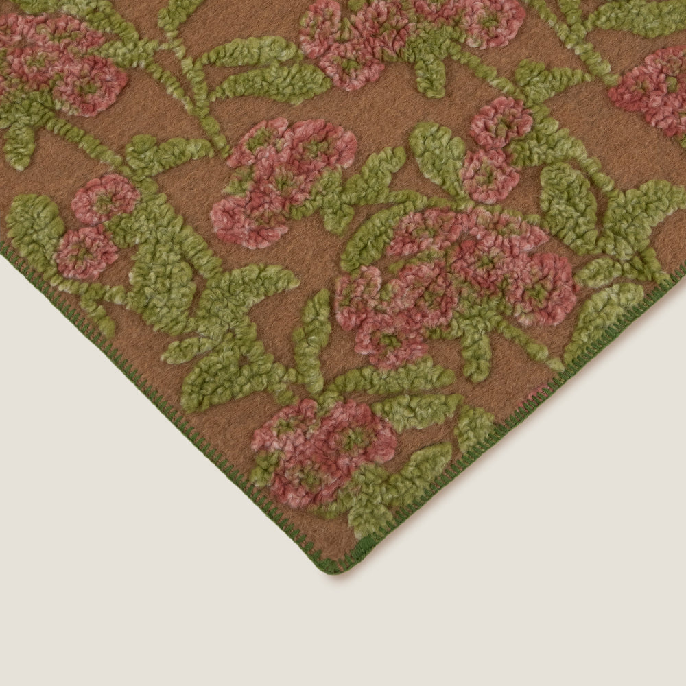 Close up of the green blanket sticking edge of the frati old flower wool throw.