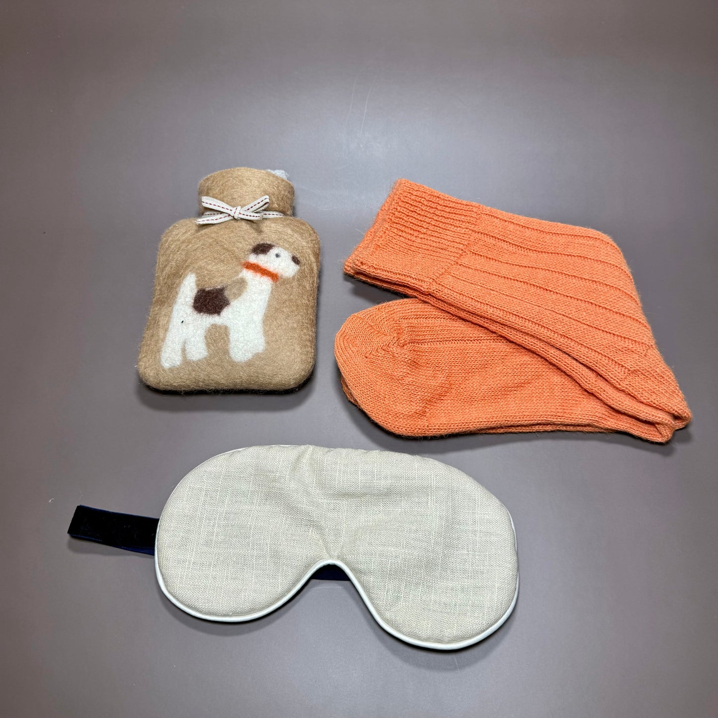 Small handmade hotwater bottle with terrier motif, Alpaca orange bed socks and natural linen sleep mask. All in a magnetic gift box.