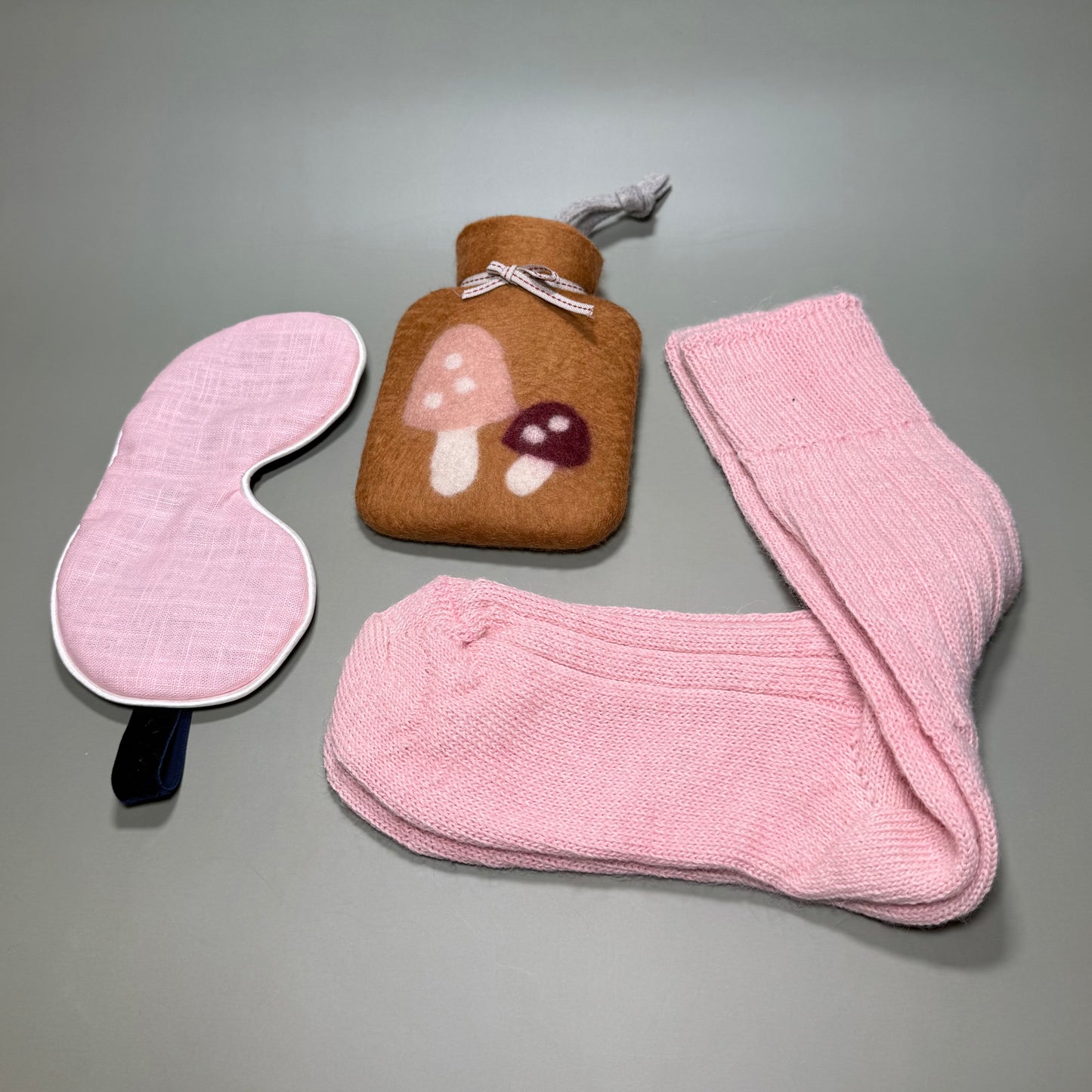 Small handmade hotwater bottle with mushroom motif, Alpaca pink bed socks and pink linen sleep mask. All in a magnetic gift box.
