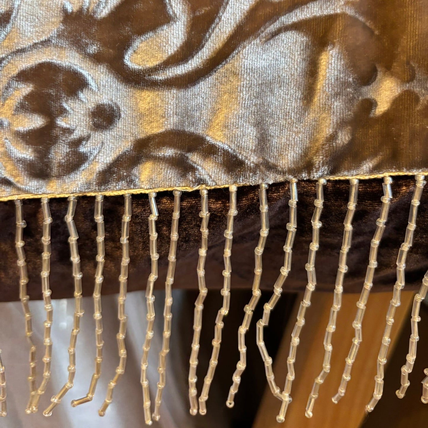 Beaded fringe detailing on cushion edge.