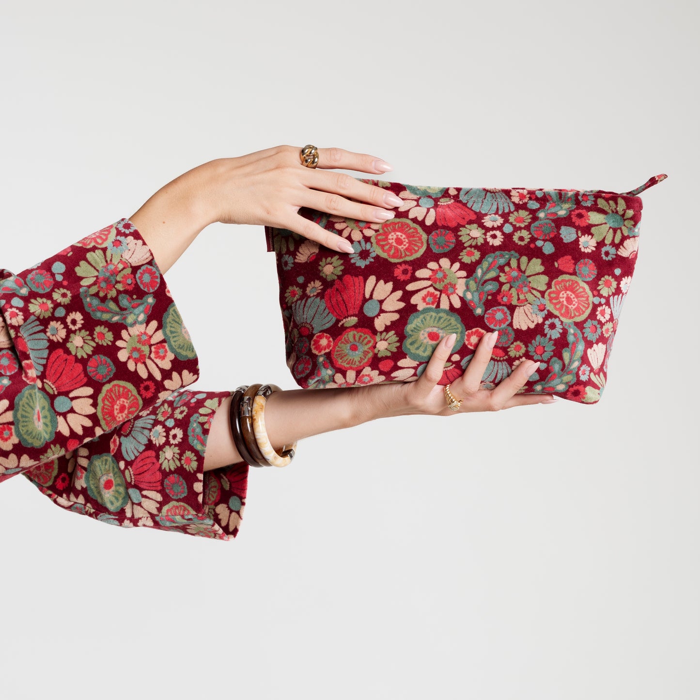 Burgundy cotton velvet washbag with a pink, cream, teal and green floral pattern.