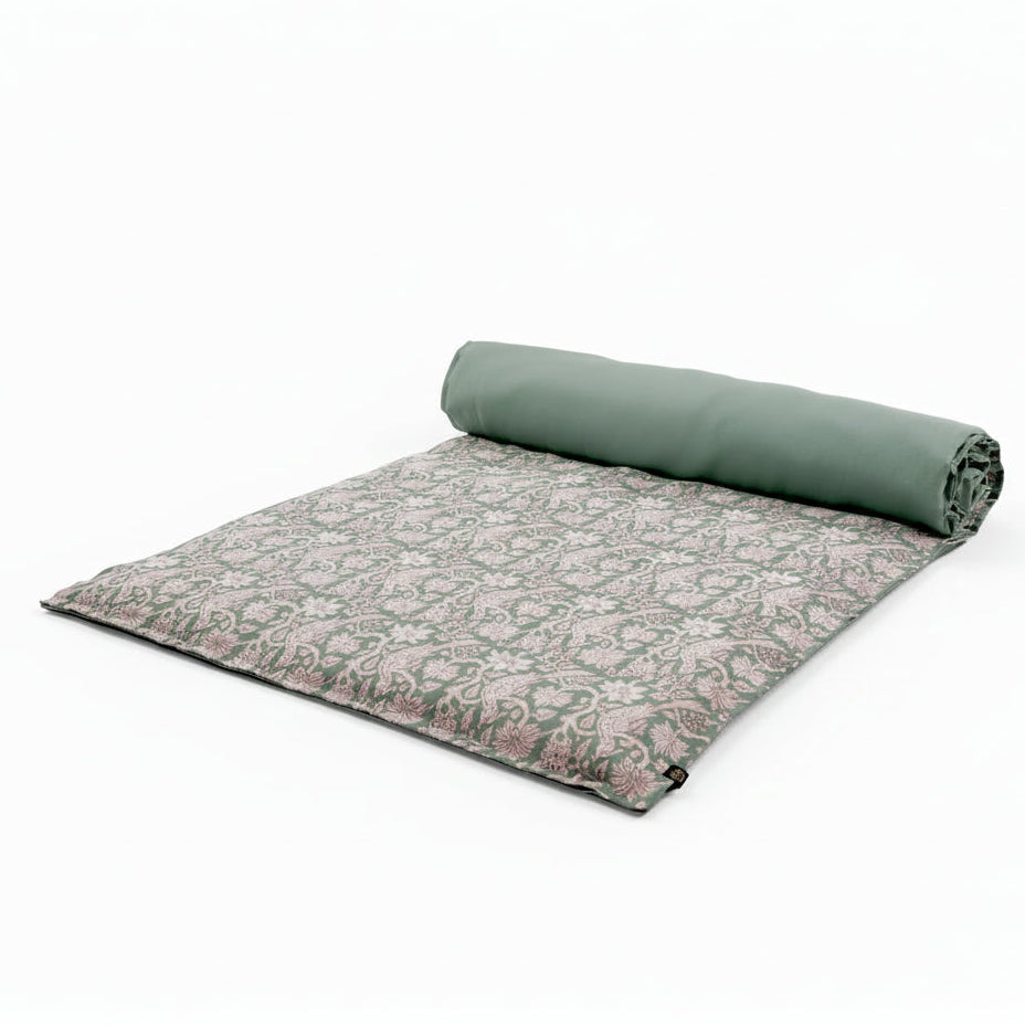 Block print linen bed scarf in a celadon blue, displayed half rolled up.
