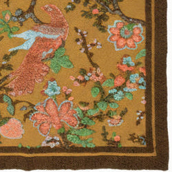 Boiled wool throw with an mustard base and brown border edge, detailed wiht blue and peach flowers with a peach bird in the centre.