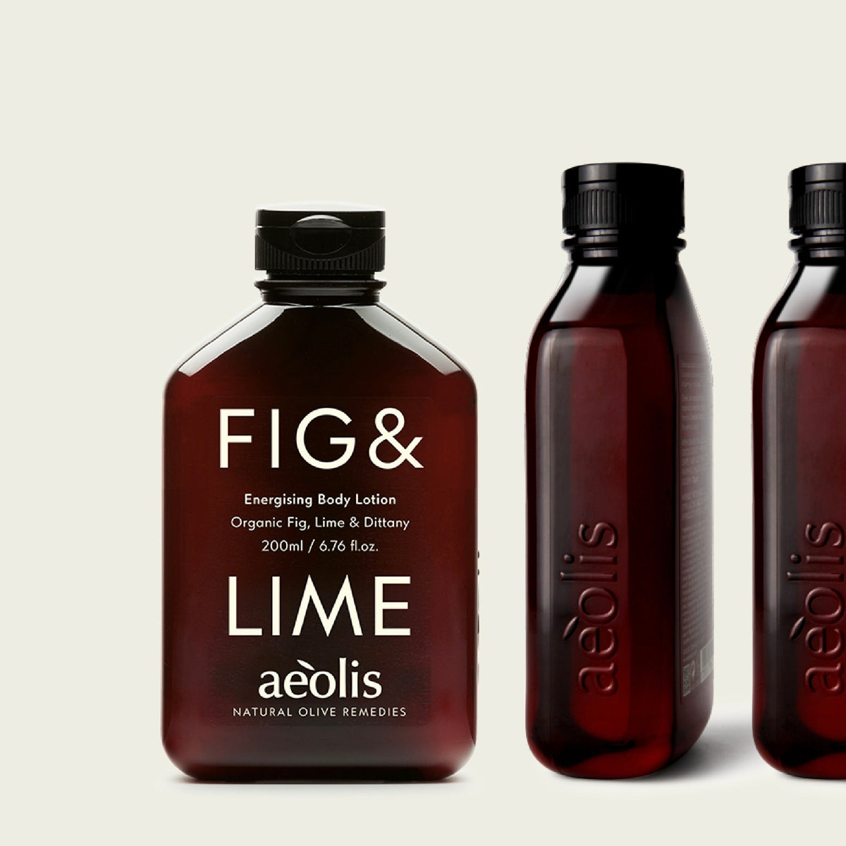 Three amber glass bottles of Aeolis Fig & Lime Exfoliating Body Lotion arranged on a light beige background, with one bottle in front and two partially visible behind it.