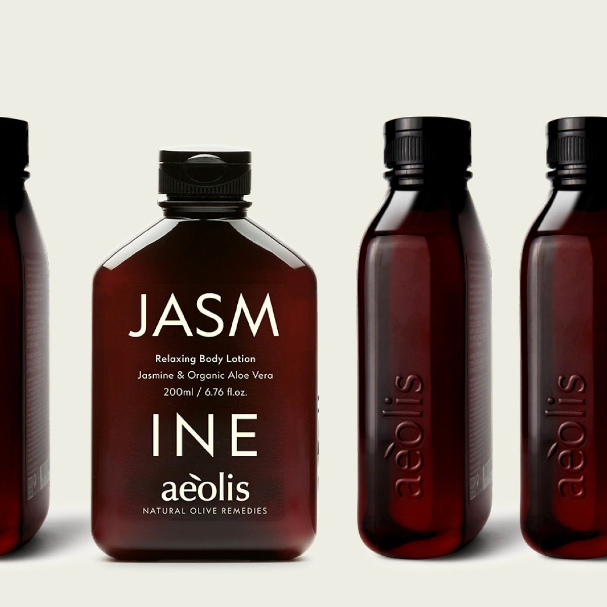 A row of amber-brown plastic bottles of Aeolis body lotion on a light beige background, with the center bottle labeled 'JASM' in white text.