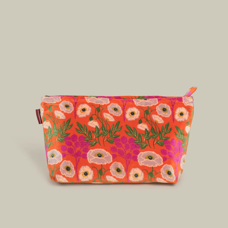 A rectangular zippered pouch with a vibrant orange-red background and a dense floral print featuring pink, white, and purple flowers with green leaves, set against a solid light gray background.