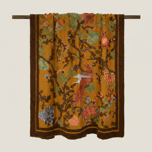 Birds of paradise wool throw with a mustard base and brown border.
