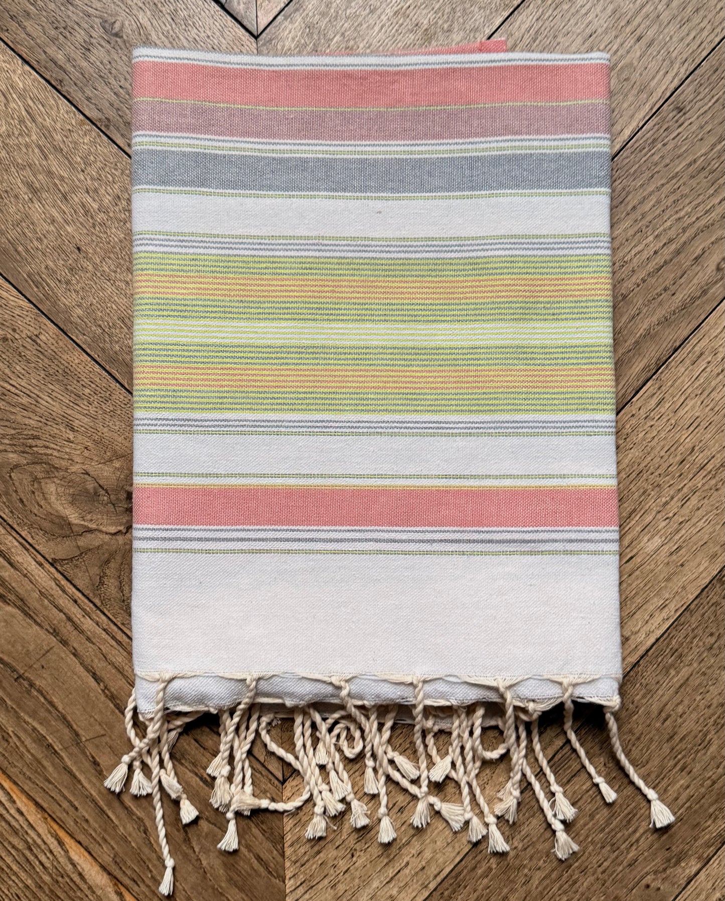 Pastel multicolour striped beach towel with a fringed edge.