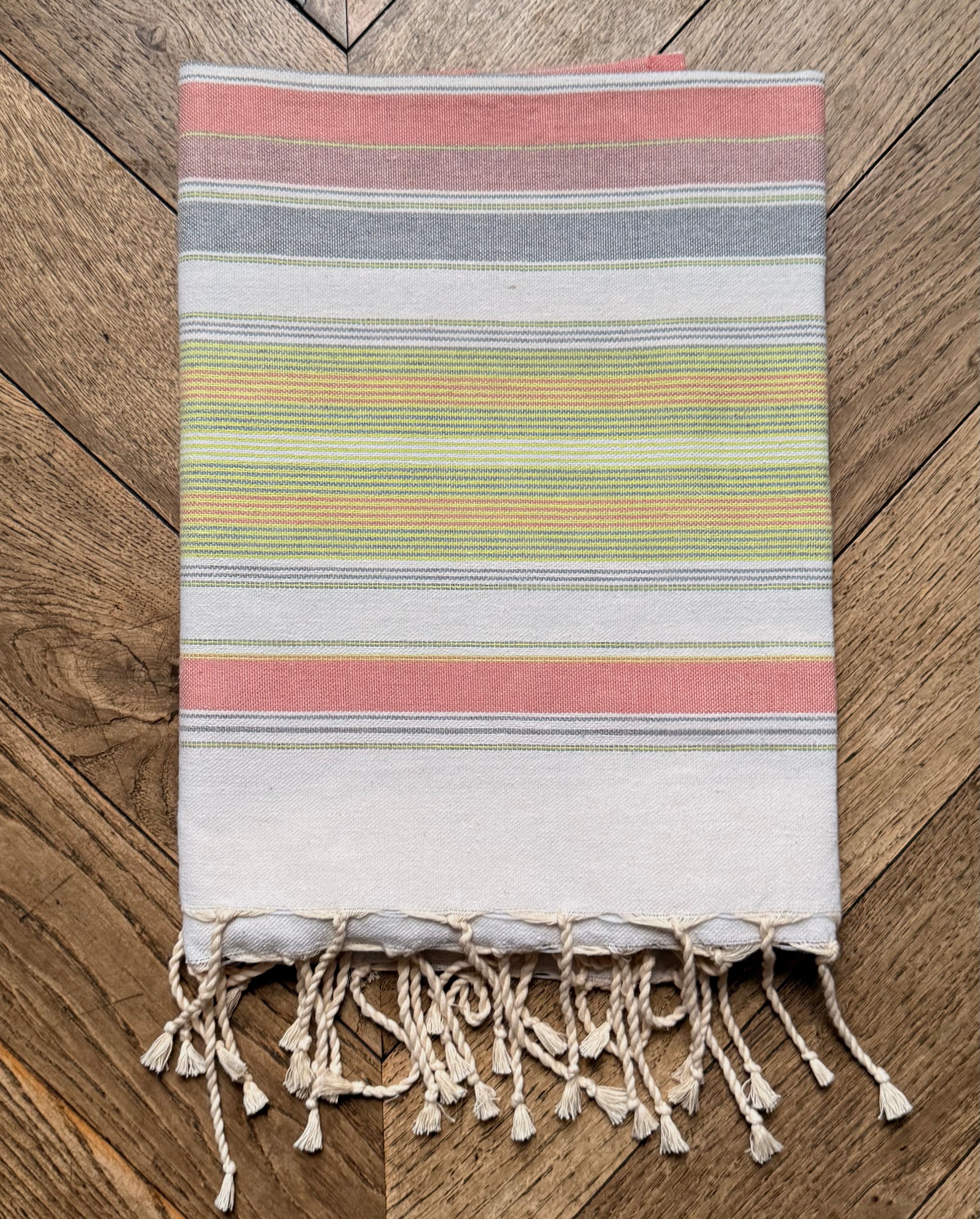 Pastel multicolour striped beach towel with a fringed edge.