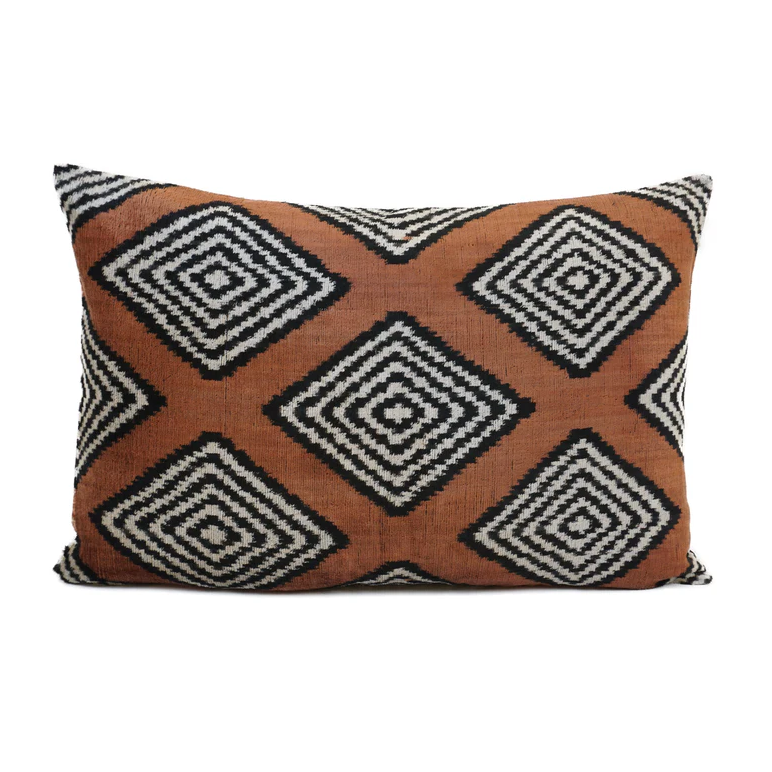 Soft brown velvet cushion with black and white striped diamond shaped patterns.