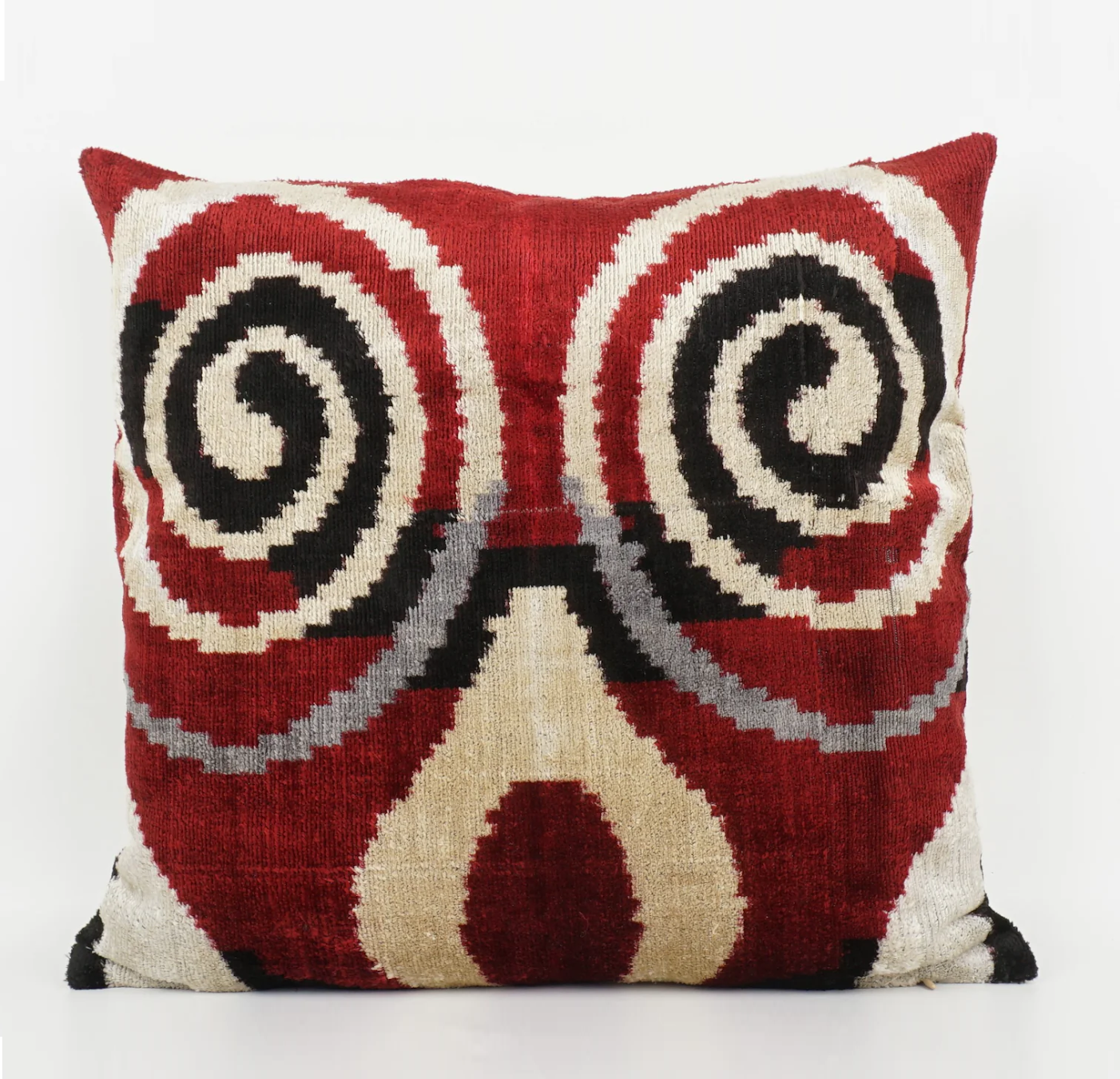 Beige swirl pattern on a red based silk ikat cushion with black detailing.