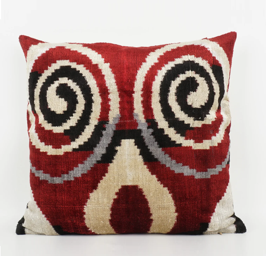 Beige swirl pattern on a red based silk ikat cushion with black detailing.