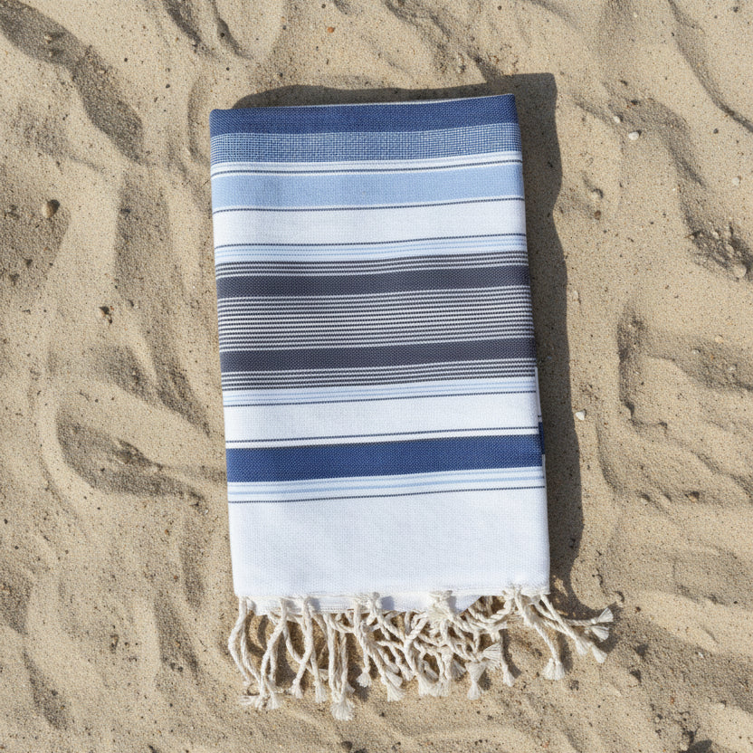Blue and white striped beach towel with a fringed edge.