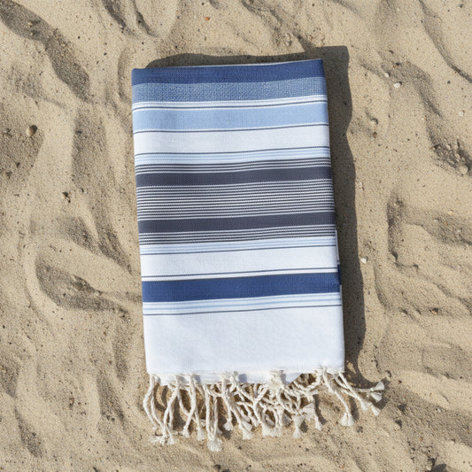Blue and white striped beach towel with a fringed edge.