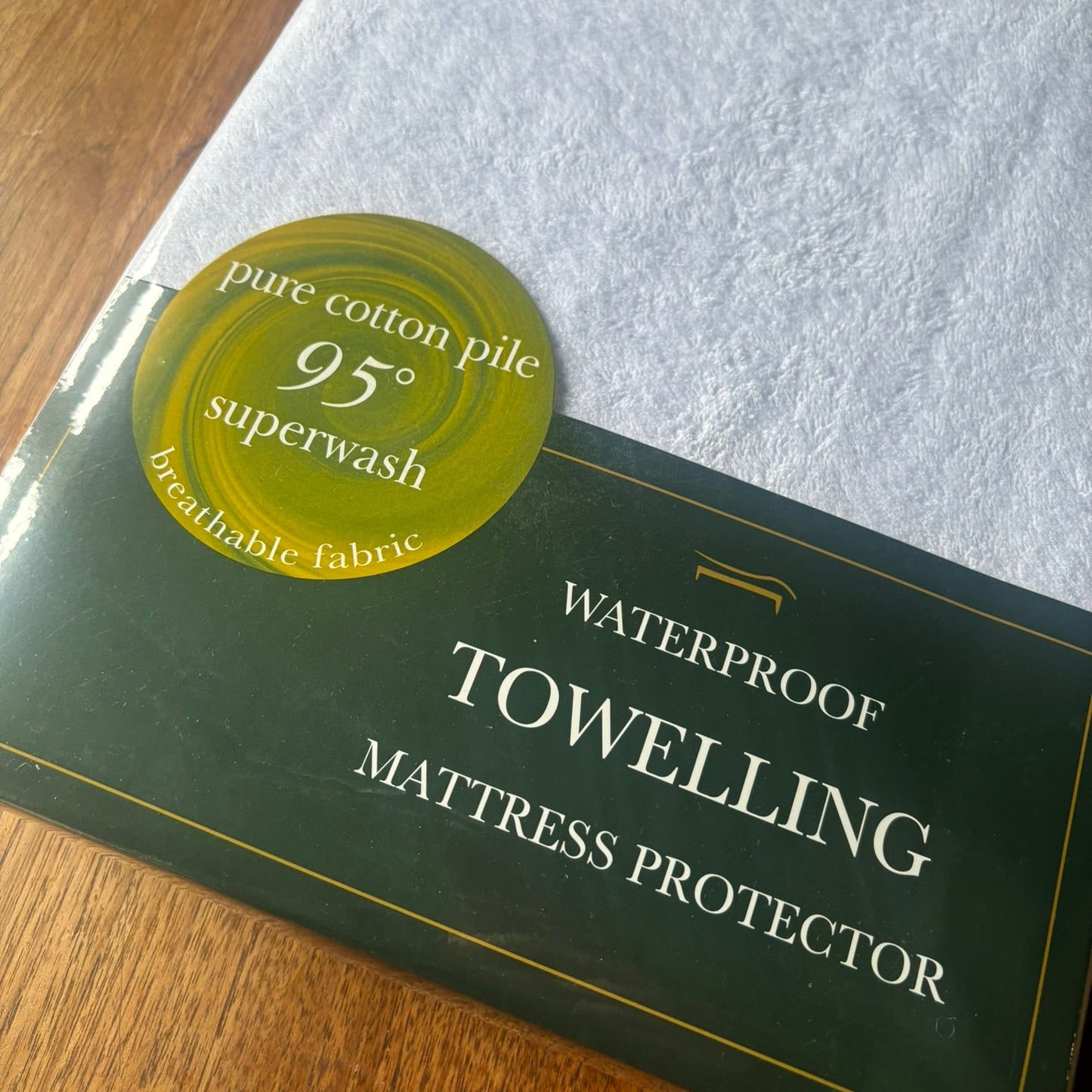 Cotton towelling waterproof mattress protector shown in its packaging.