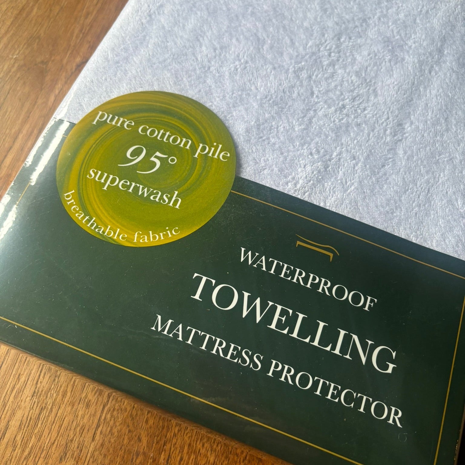 Cotton towelling waterproof mattress protector shown in its packaging.