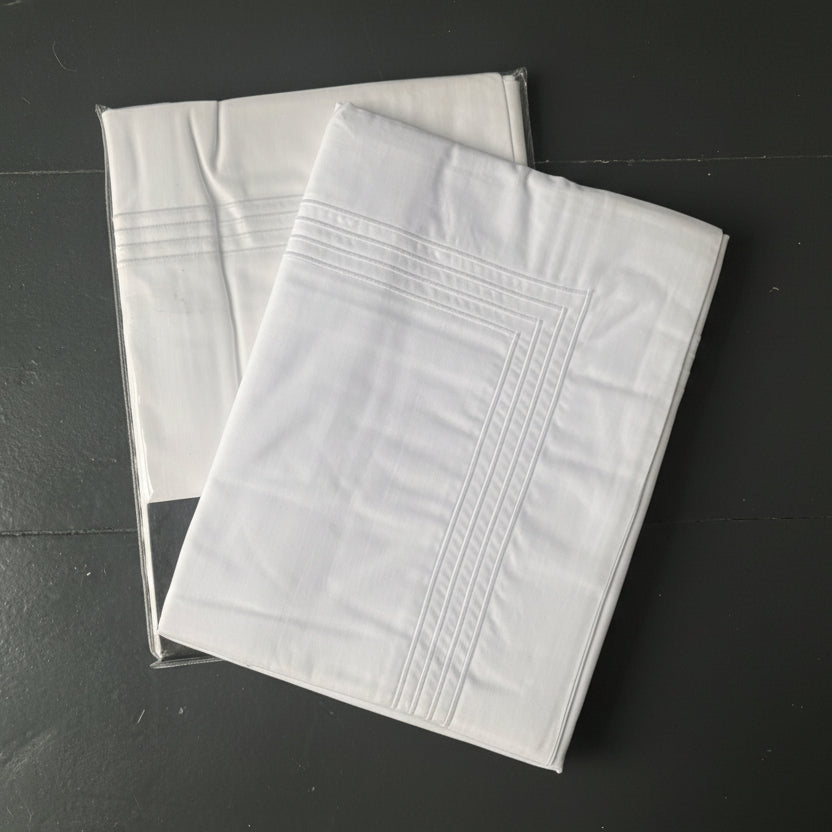 White 4 row cord king white pillowcases, one shown in packaging and one shown without.