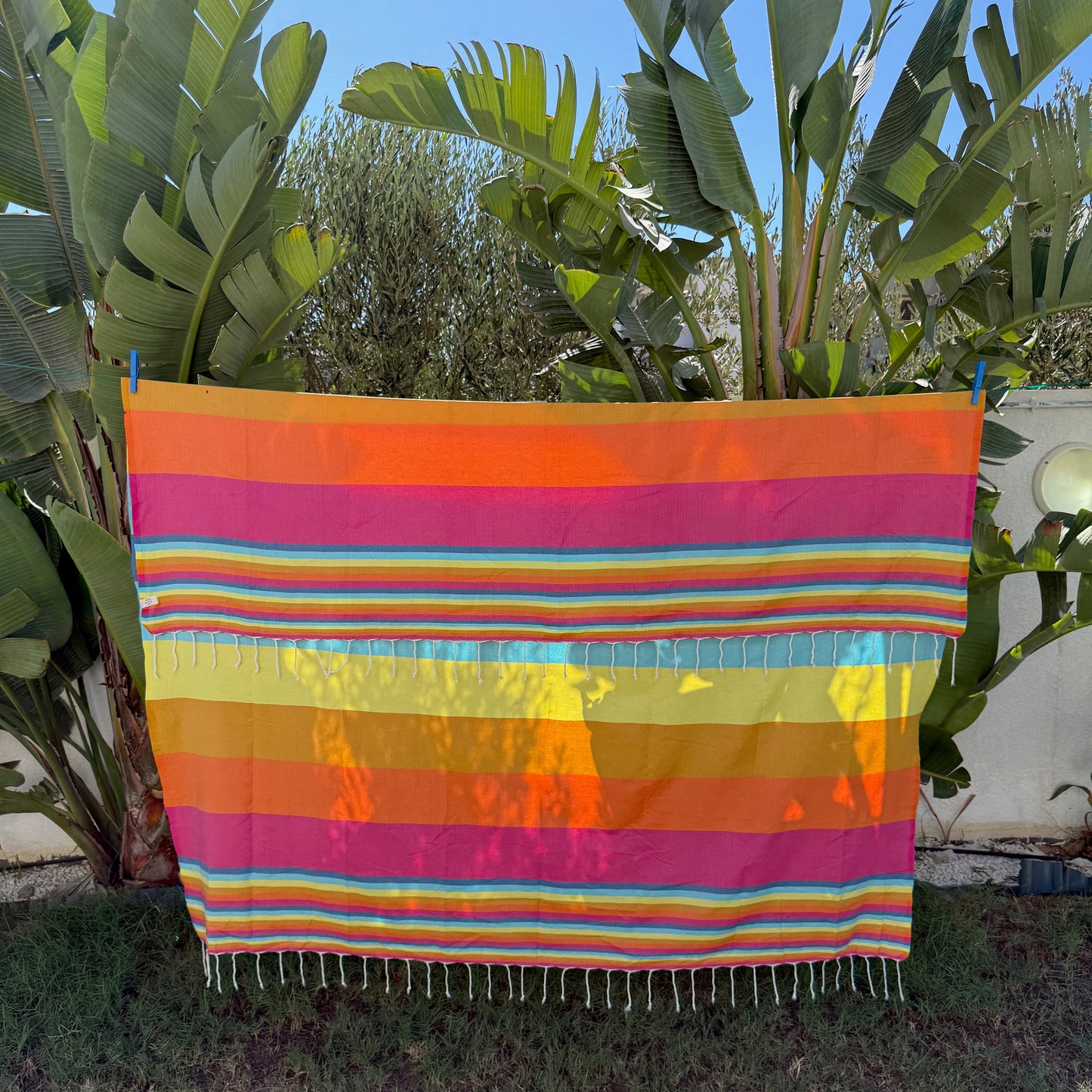 Rainbow striped double beach towel with a fringed edge.