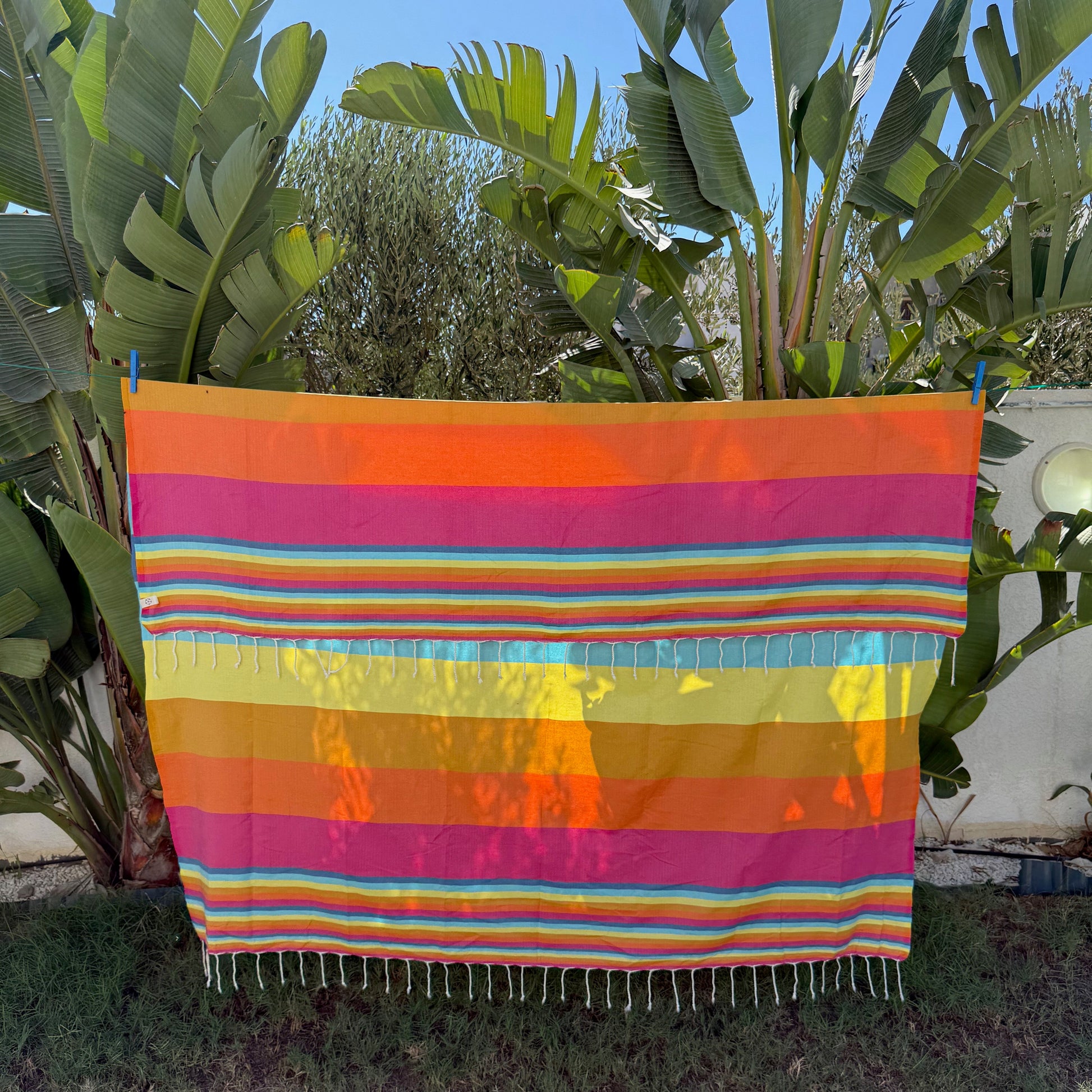 Rainbow striped double beach towel with a fringed edge.