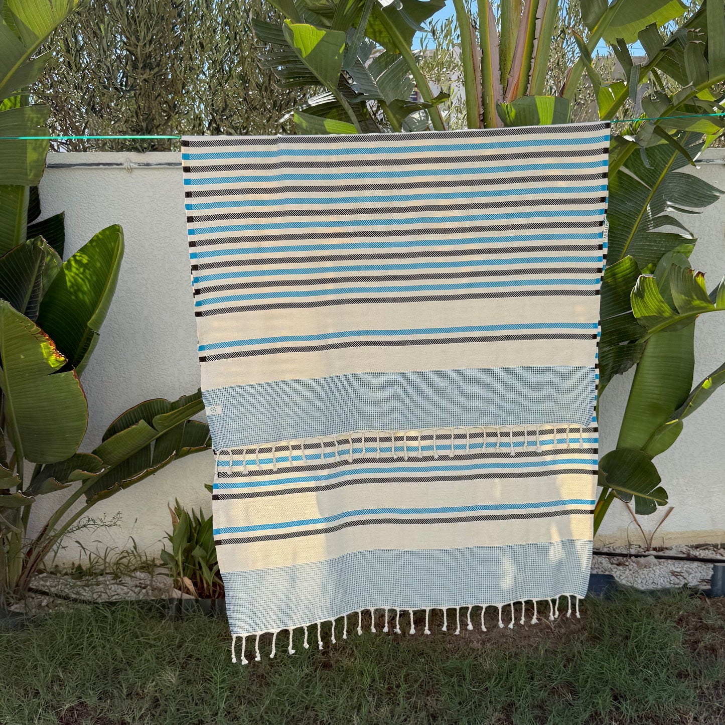 Blue, grey and white striped beach towel.