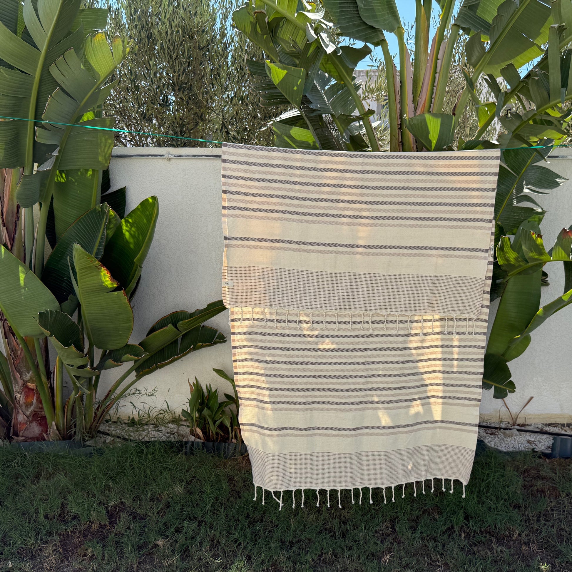Grey, beige and white striped beach towel.