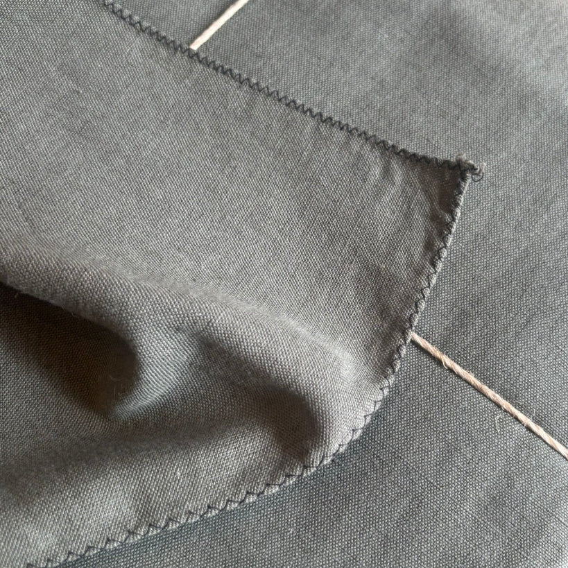 Khaki coloured linen/cotton tablecloth with black overlocked edge