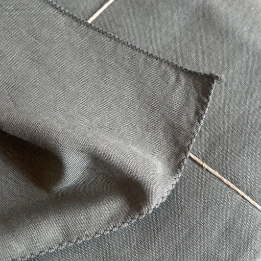 Khaki coloured linen/cotton tablecloth with black overlocked edge