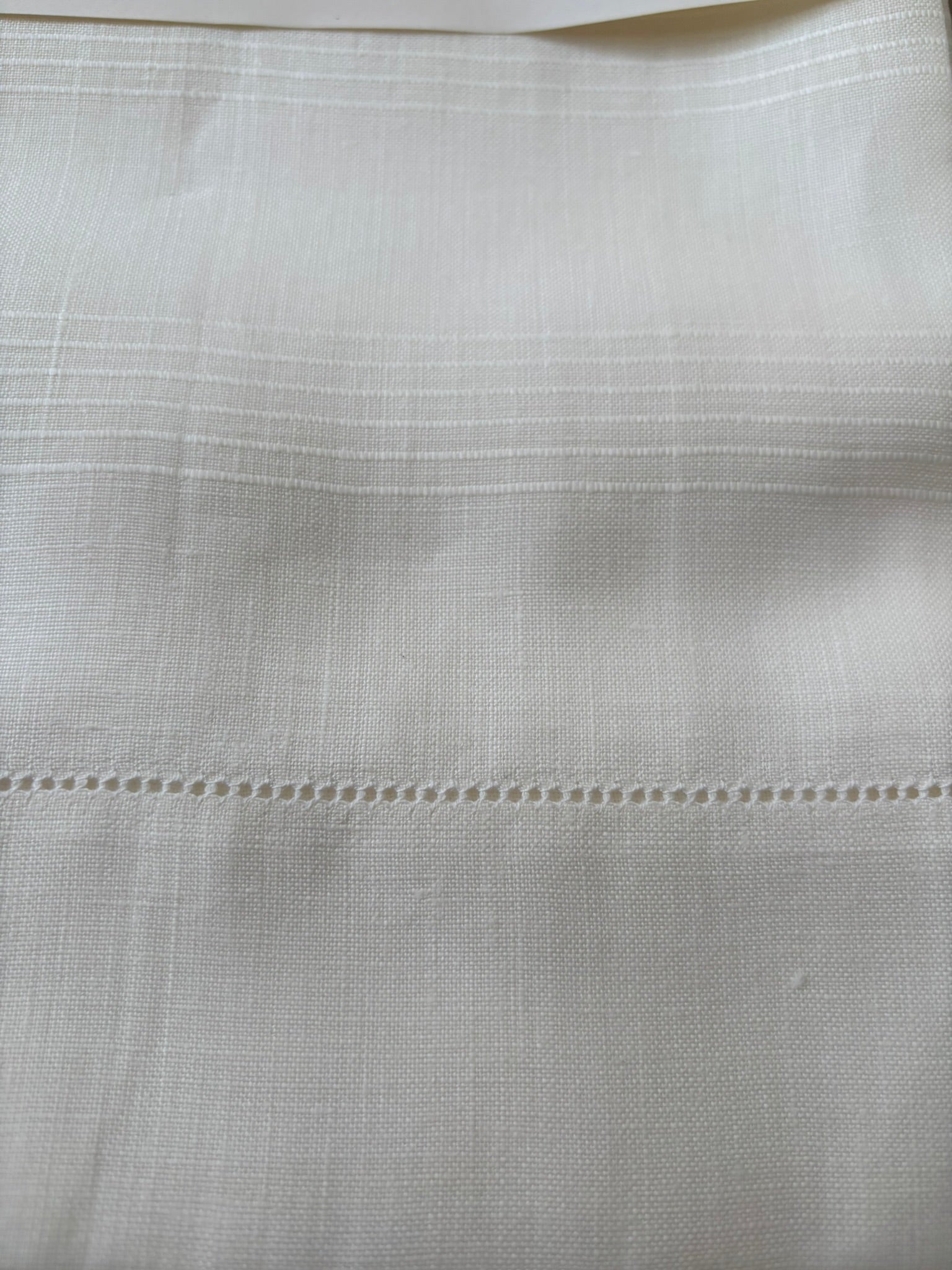 Close up of vintage Italian white linen hand towels with hemstitching and woven detail.
