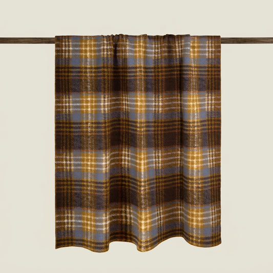 A plaid curtain panel hanging from a dark wooden rod against a solid light beige background. The plaid pattern features brown, mustard yellow, slate blue, and white stripes.