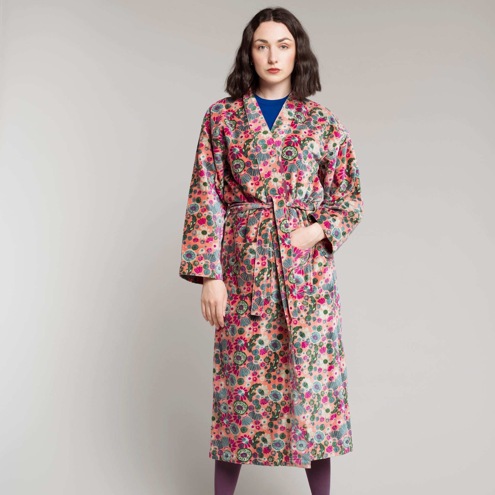 Coral cotton velvet robe with a multi coloured floral pattern.