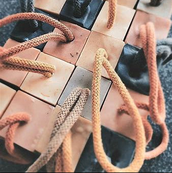 Multiple Vely different fragranced soap on a rope close up.