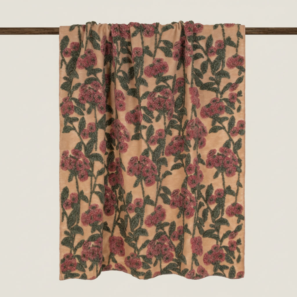 Beige boiled wool throw with a red and green floral pattern throughout.