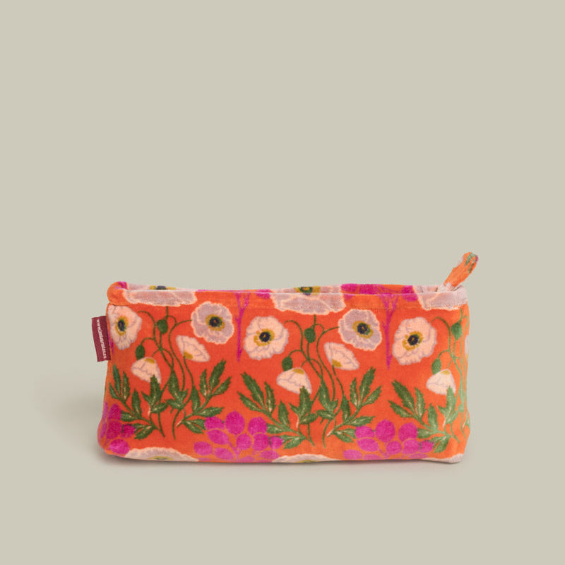 A small zippered pouch with a vibrant orange-red background and an embroidered floral pattern featuring pink, white, and green poppies, shown against a solid light gray background.