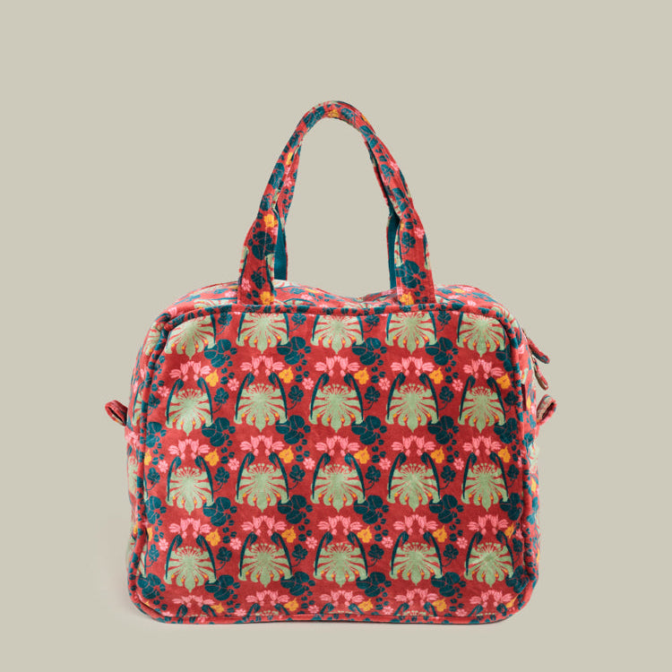 A large tructured tote bag with a colorful floral and leaf pattern in red, pink, green, and blue, set against a solid light gray background.