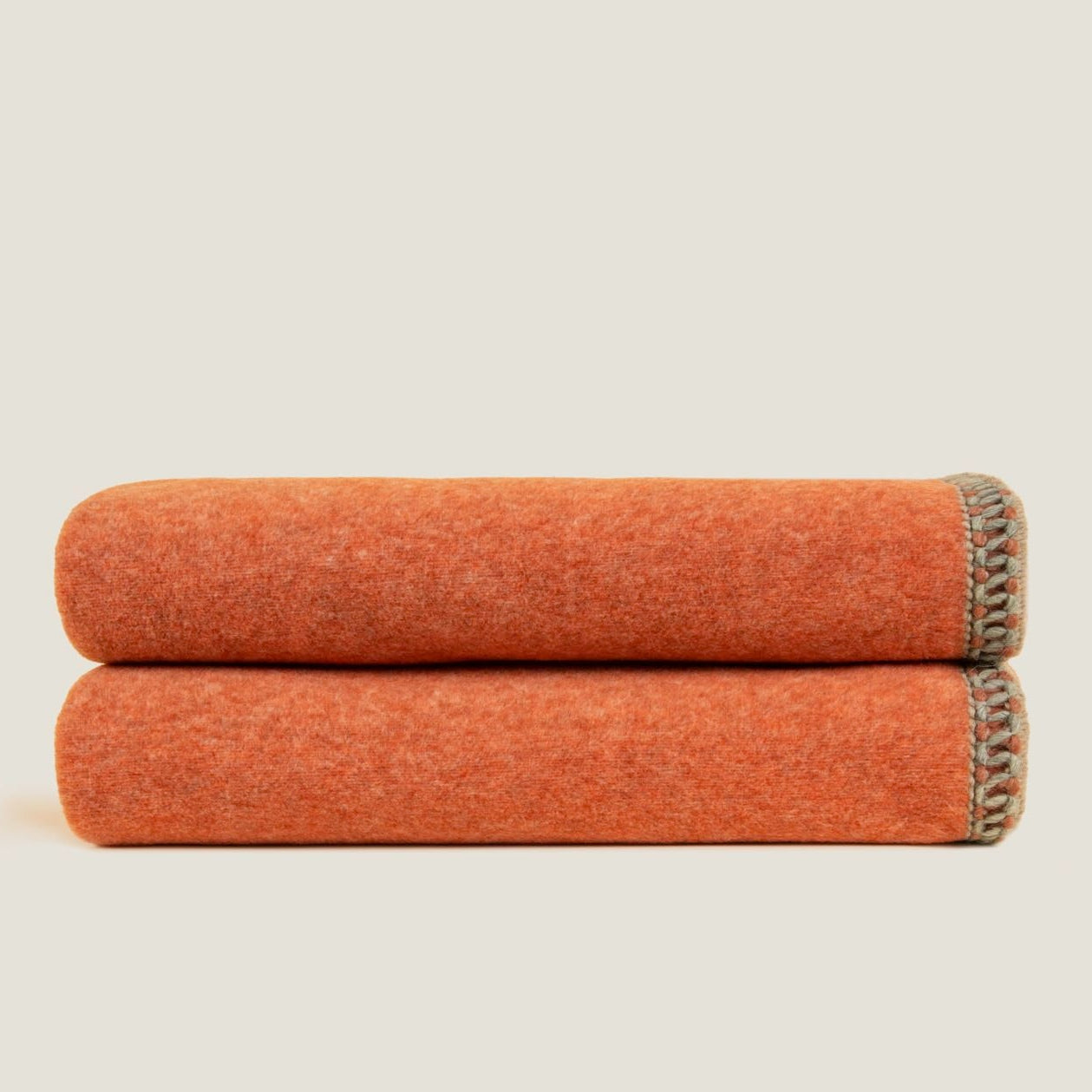 Apricot bamboo throw displayed folded showing the braided edging. 