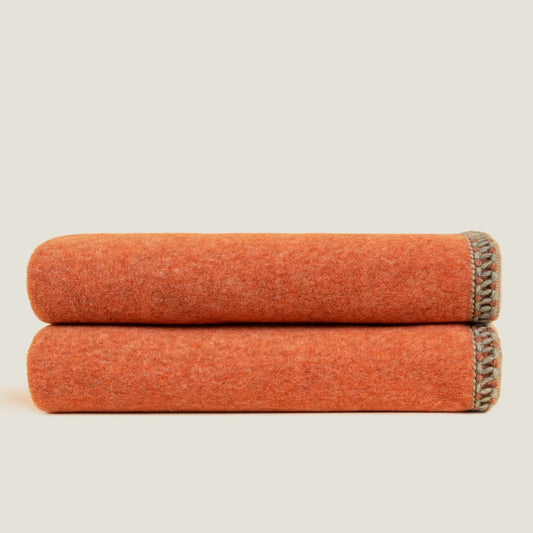 Apricot bamboo throw displayed folded showing the braided edging. 