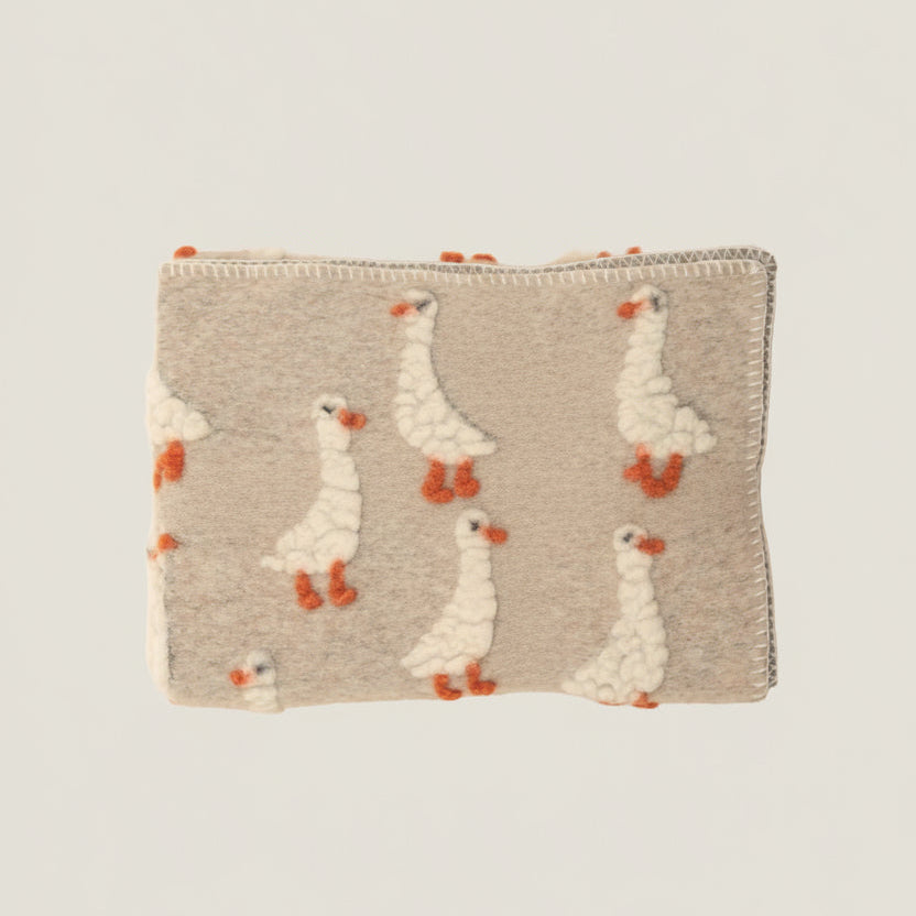Beige wool  throw with felted duckling pattern.