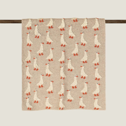 Beige boiled wool baby blanket patterned with duckings.