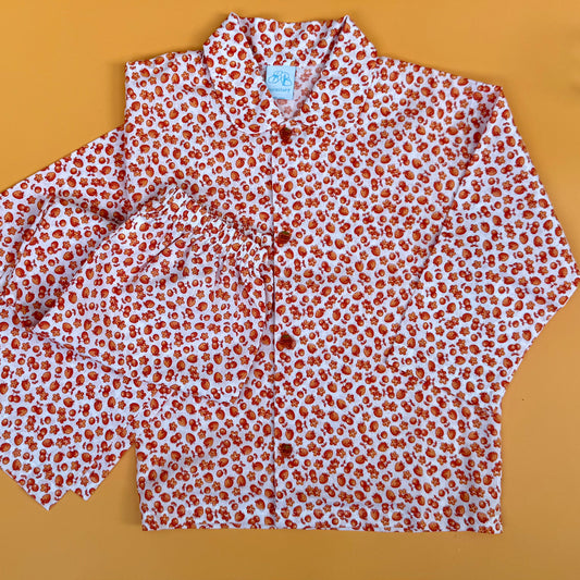 white cotton pyjamas with tiny orange fruit print. Orange fruit buttons