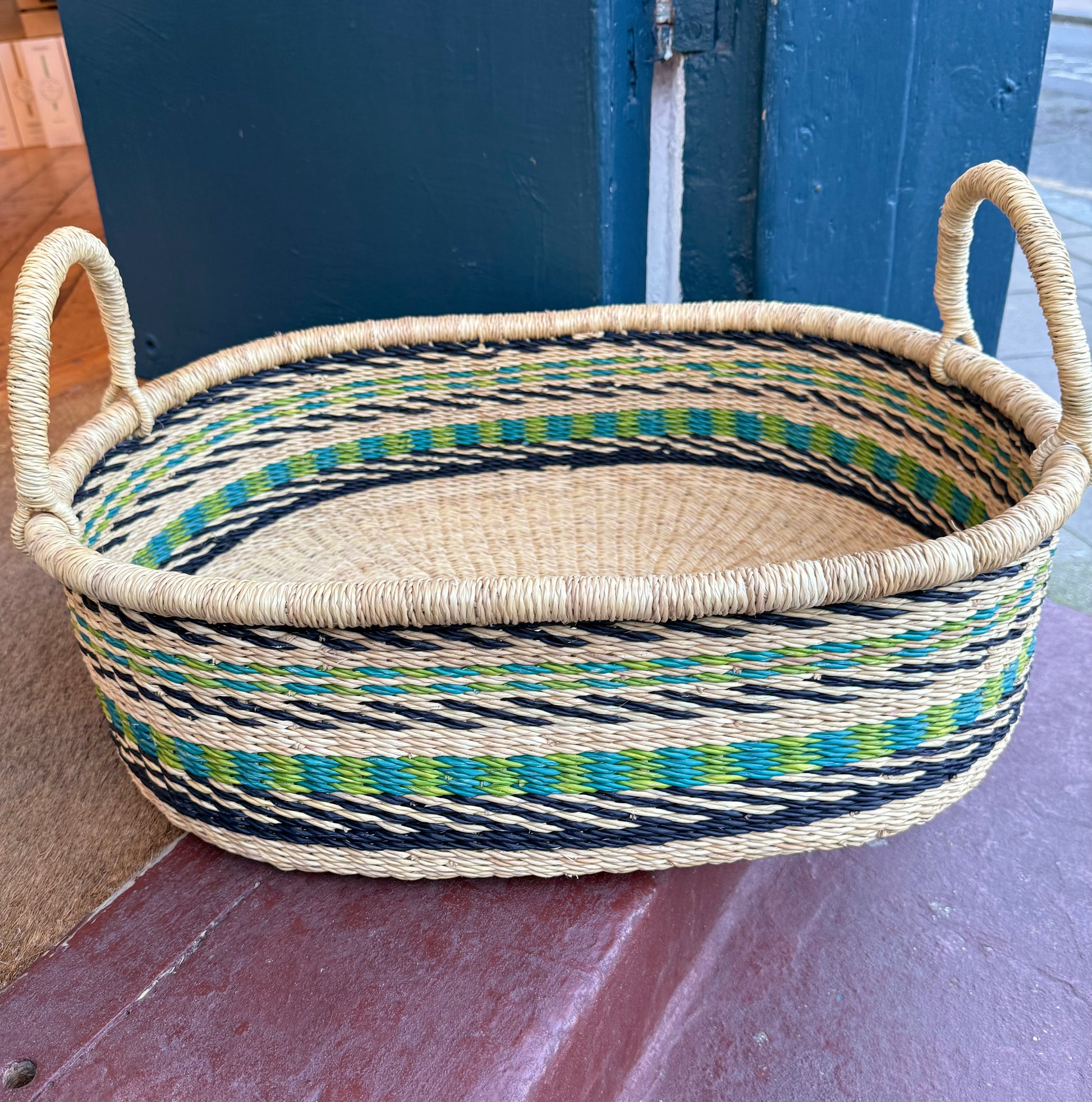 Hand woven tray with a blue and green oven pattern throughout.