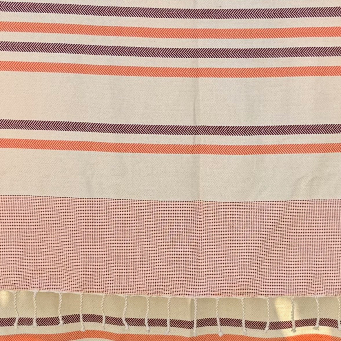 Close up of antibes orange fouta showing the striped pattern.