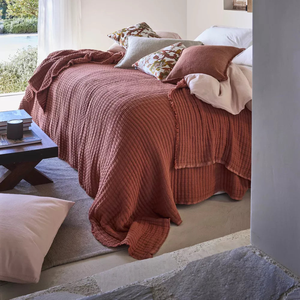 Moccacino tivoli cotton bedspread shown draped across a bed.