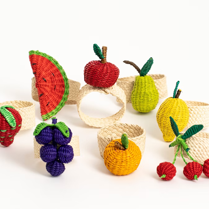 Fruit and vegetable woven napkin rings presented bunched next to eachother.