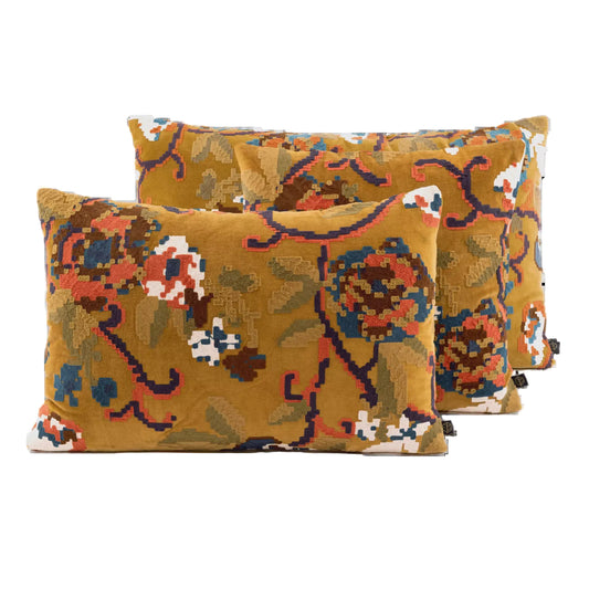 Three decorative throw pillows with a textured floral pattern in mustard yellow, brown, blue, and white, arranged against a plain white background.