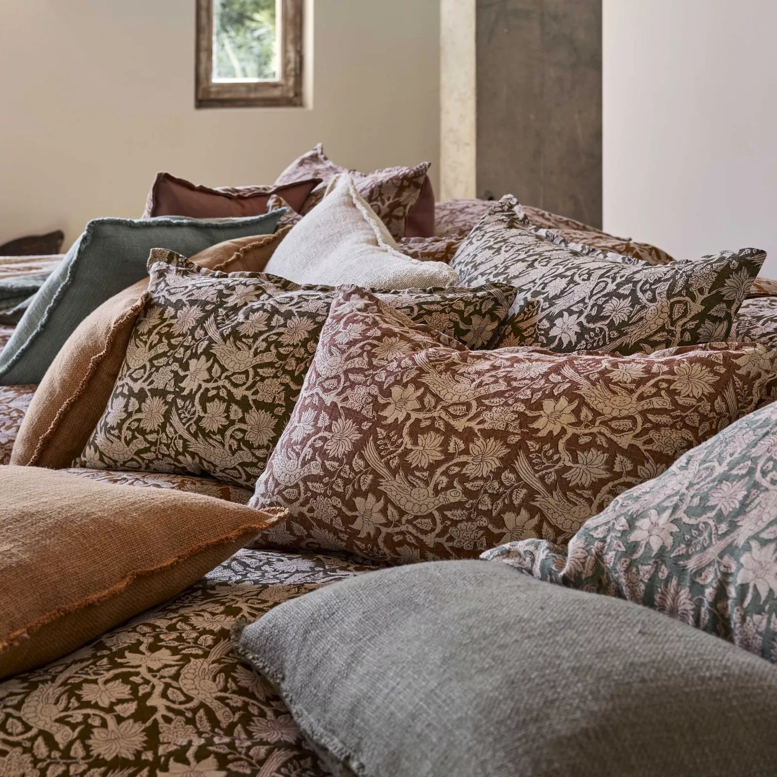 Block Printed linen cushion range displayed on a bed.