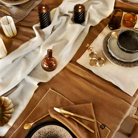 Verona gold linen/cotton table runner and napkins set at a table.